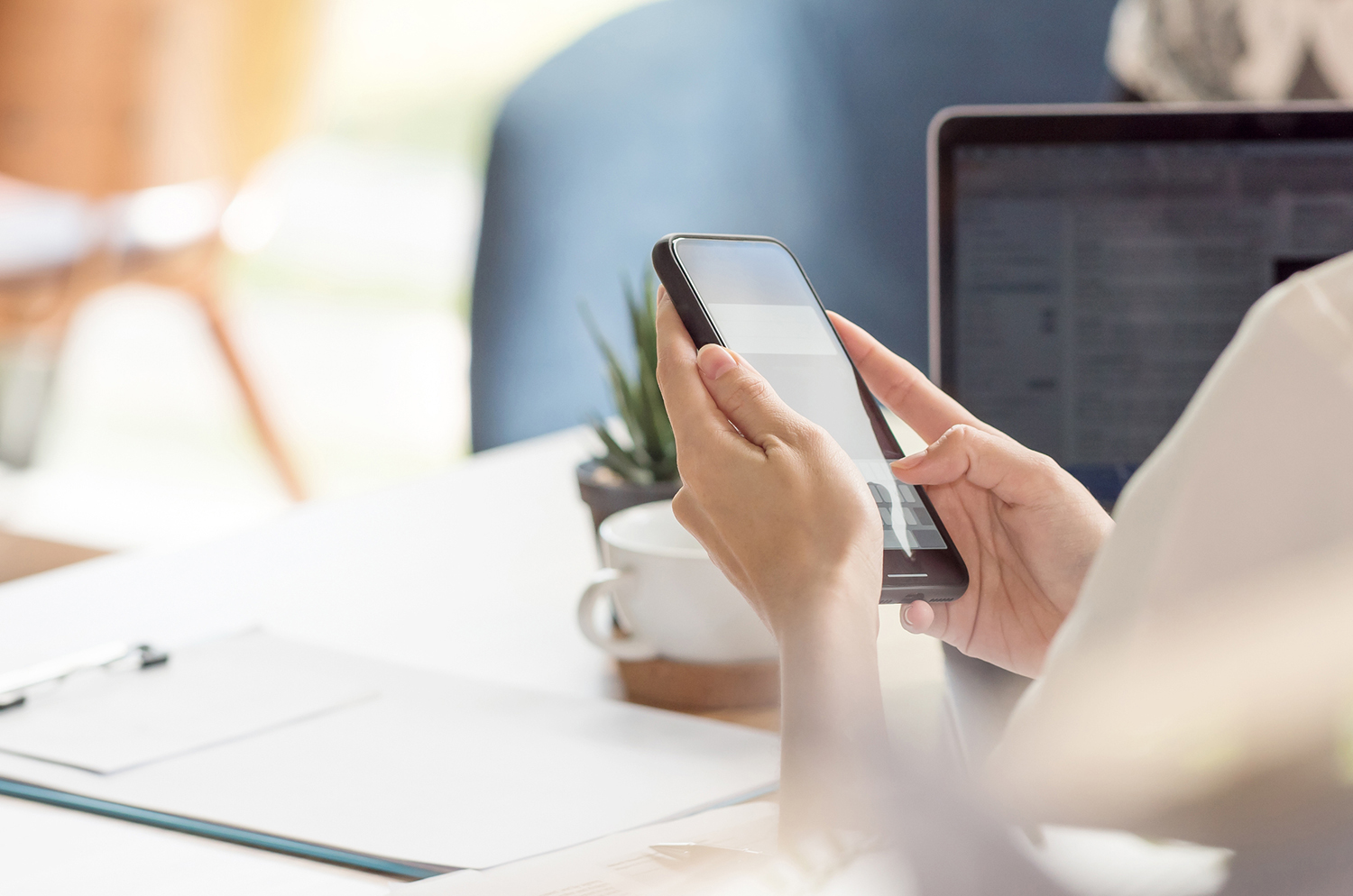 femme professionnelle - business women avec un smartphone cabinet fontanès digitalise ses missions grâce à des applications mobiles bureau avec un ordinateur et un smartphone